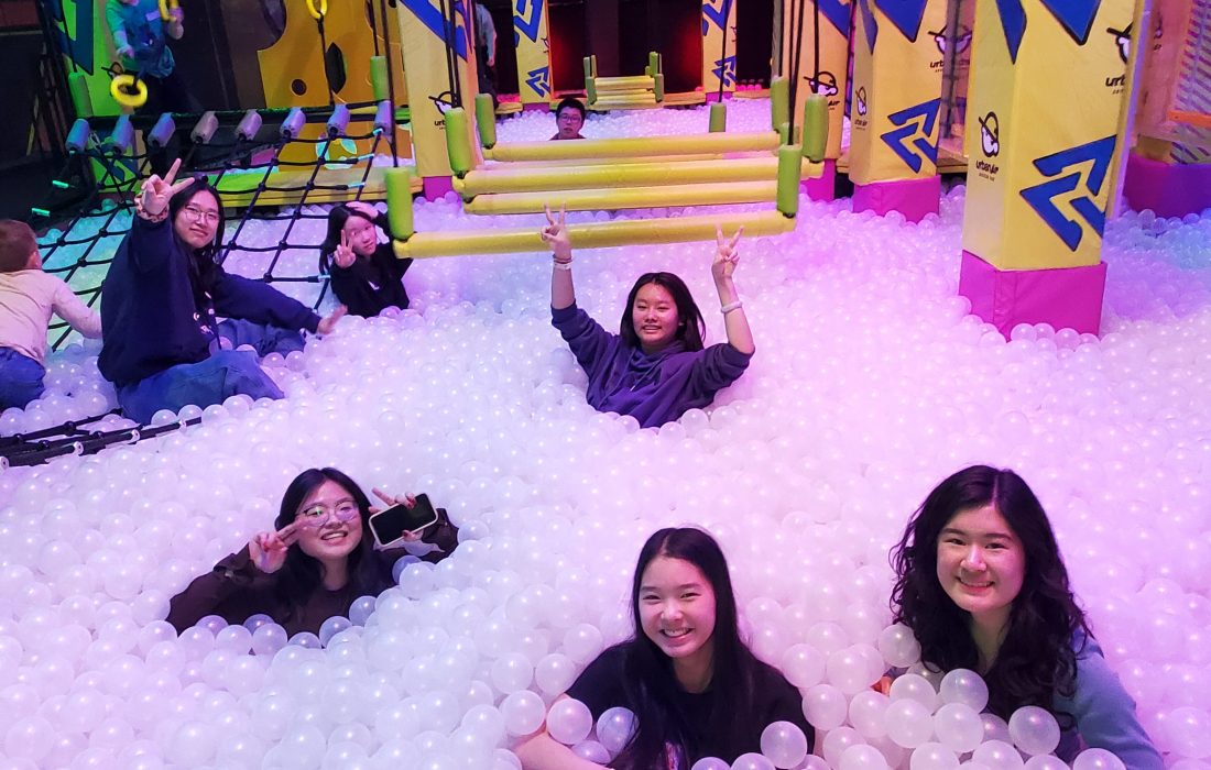 Students at Urban Air Trampoline Park in a ball pit smiling